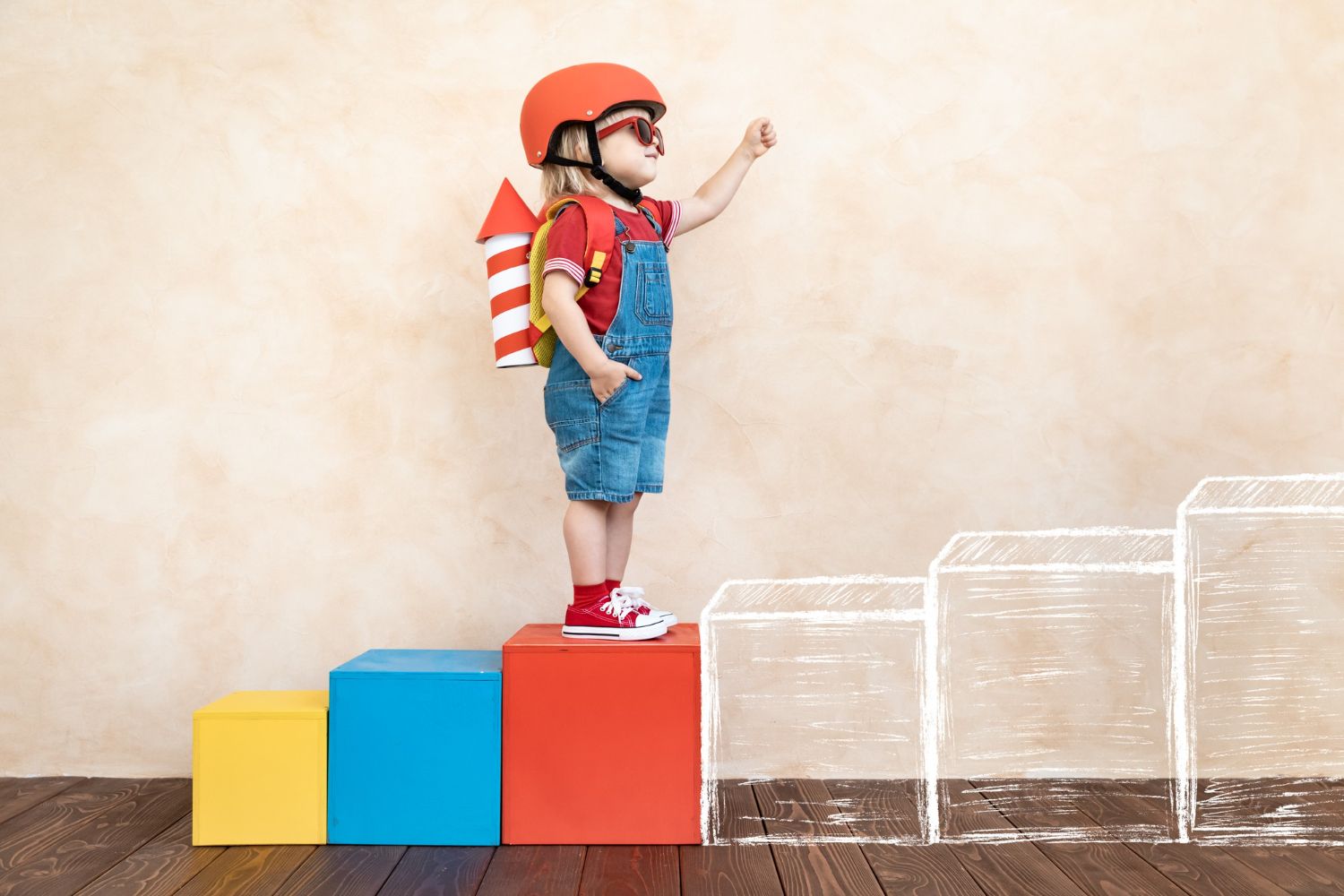 Young child with backpack climbing colorful play blocks at The Skills Lab